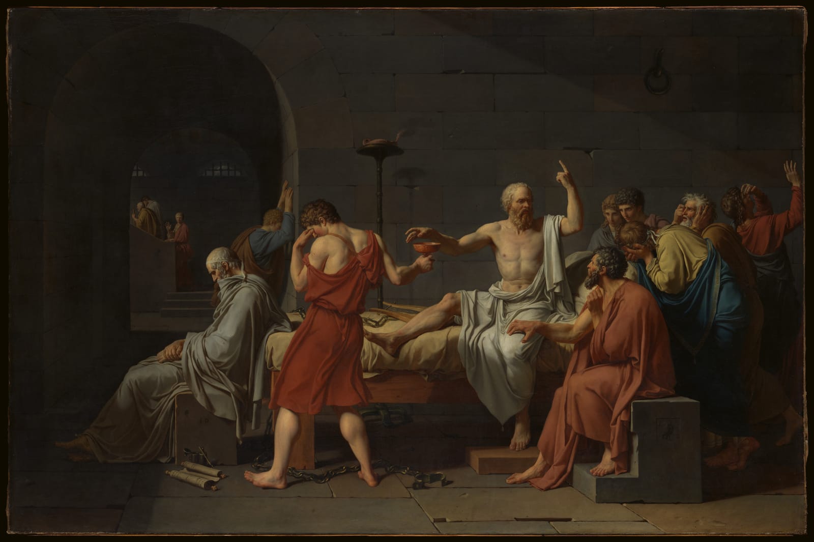A painting of a stone prison room: Socrates, bare-chested, sits on his bed with one finger raised, reaching for a cup held out by a young man who covers his eyes, while his friends weep around him.