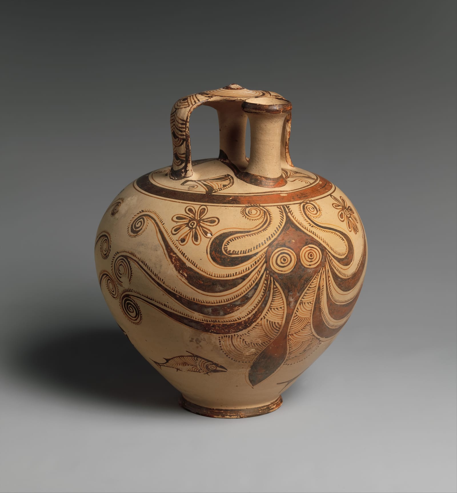 A round pale clay jar with a small spout and stirrup-shaped handle, painted in brown with an octopus whose curling arms wrap around the body.