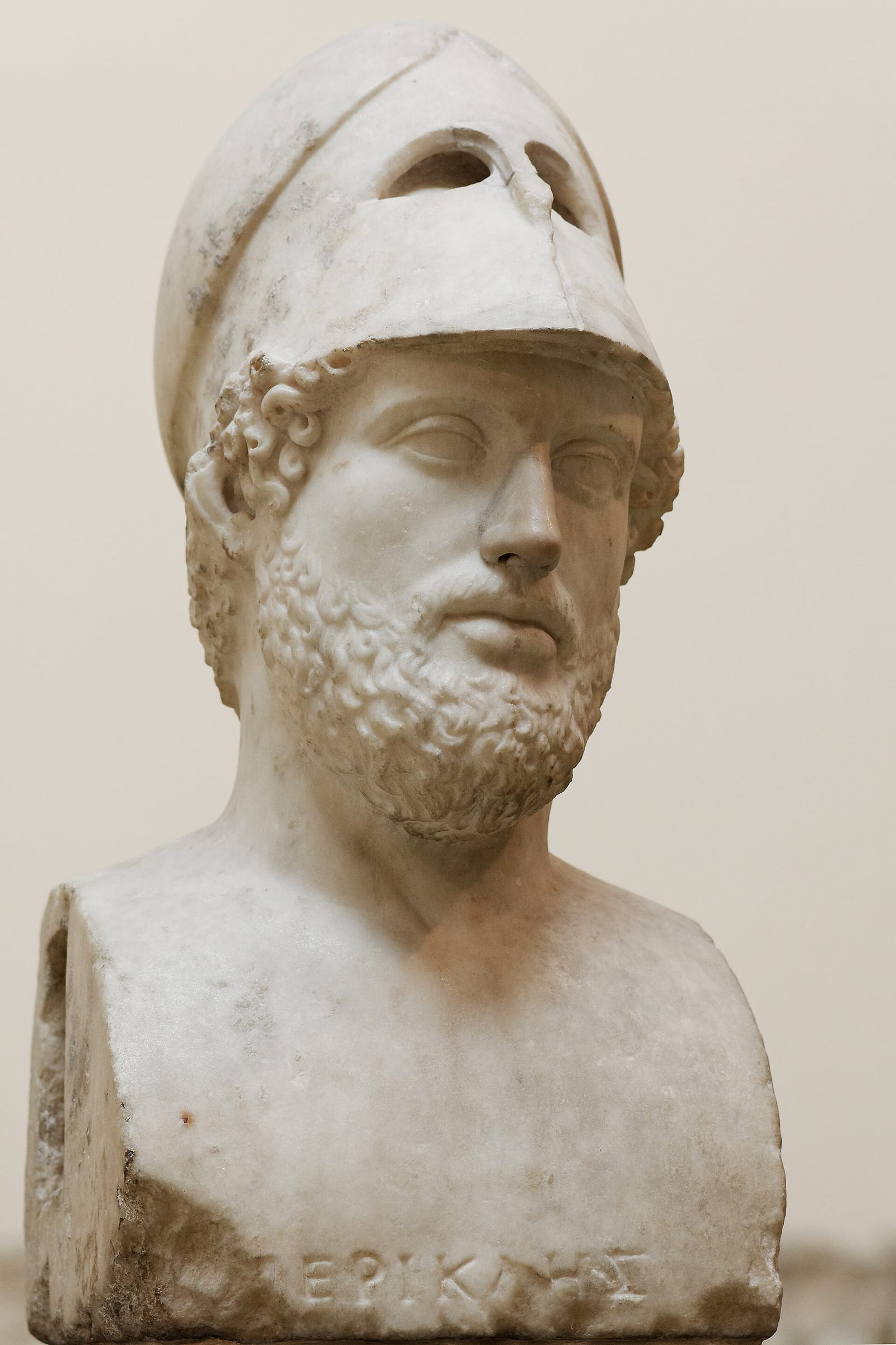 A marble portrait bust of a bearded man wearing a helmet pushed back on his head; the name Pericles is carved below.